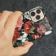 Main tenant un téléphone avec une coque à motif floral