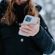 Personne tenant un smartphone dans la neige
