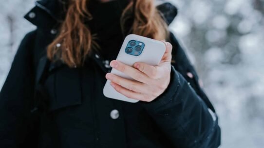 Personne tenant un smartphone dans la neige