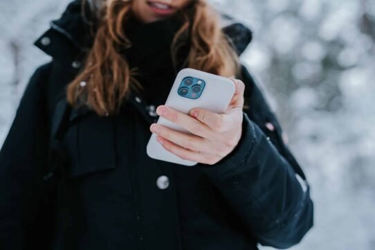 Personne tenant un smartphone dans la neige