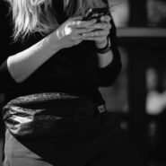 Femme tenant un smartphone avec une banane à la taille