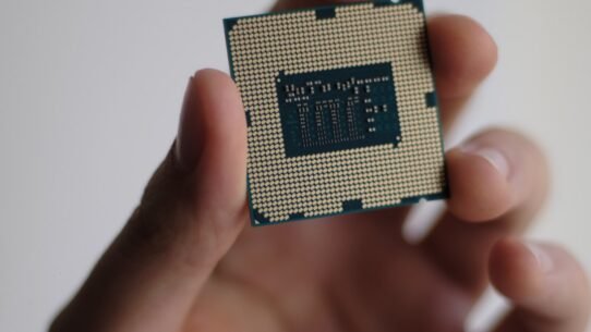 Main tenant un microprocesseur sur fond neutre