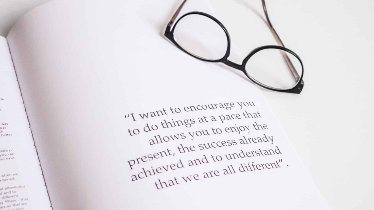 Lunettes posées sur un livre ouvert avec une citation