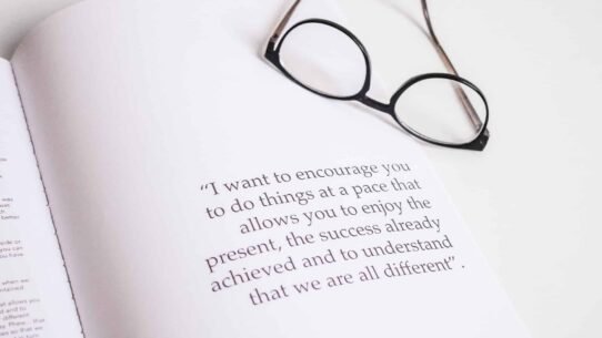 Lunettes posées sur un livre ouvert avec une citation