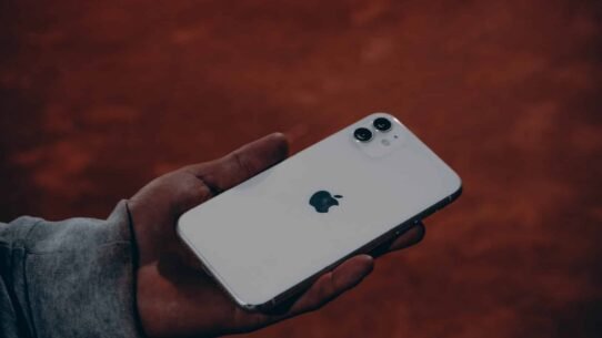 Main tenant un smartphone moderne sur fond flou