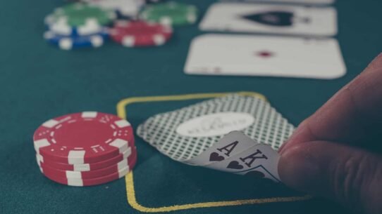 Main de poker avec des cartes et jetons sur une table