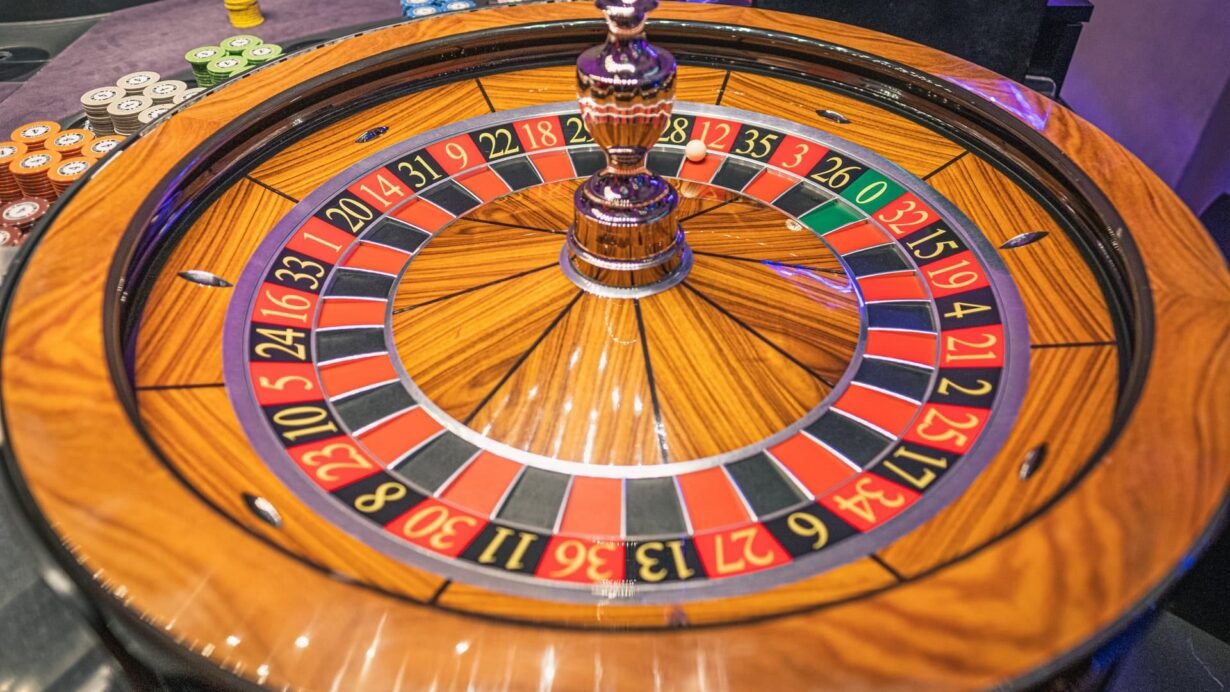 Roulette de casino en bois avec des jetons empilés autour