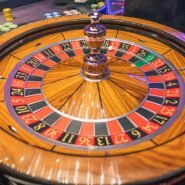 Roulette de casino en bois avec des jetons empilés autour