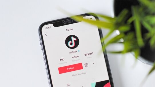 Profil TikTok ouvert sur un smartphone posé sur une table blanche