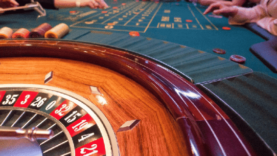 Table de roulette de casino avec joueurs en arrière-plan