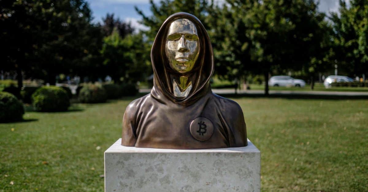 Statue en bronze avec un symbole Bitcoin sur un piédestal