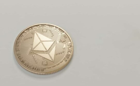 Pièce Ethereum dorée sur fond gris clair