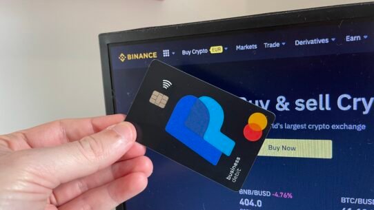 Carte bancaire tenue devant un site de crypto-monnaies