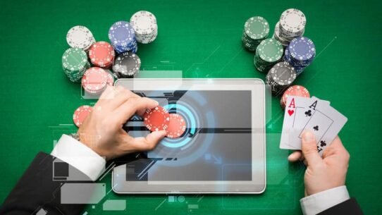 Homme jouant au poker en ligne avec des jetons et une tablette