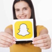 Femme souriante tenant un logo Snapchat