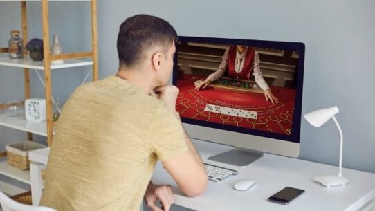 Homme regardant un écran d'ordinateur avec un jeu de casino en ligne