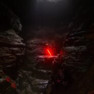 Personne dans une grotte sombre avec une épée lumineuse rouge