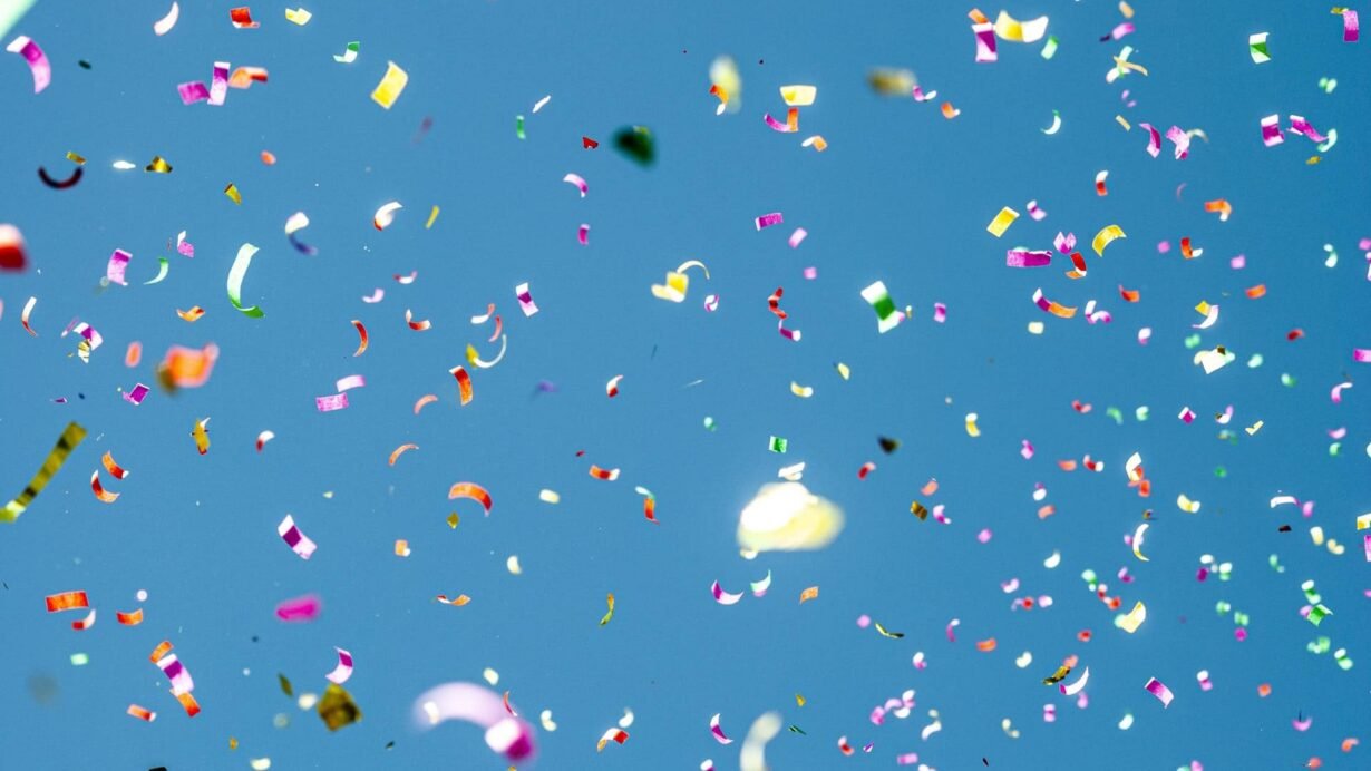 Confettis colorés flottant dans le ciel bleu