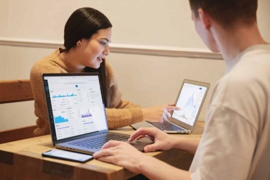 Deux personnes analysant des graphiques sur des ordinateurs portables