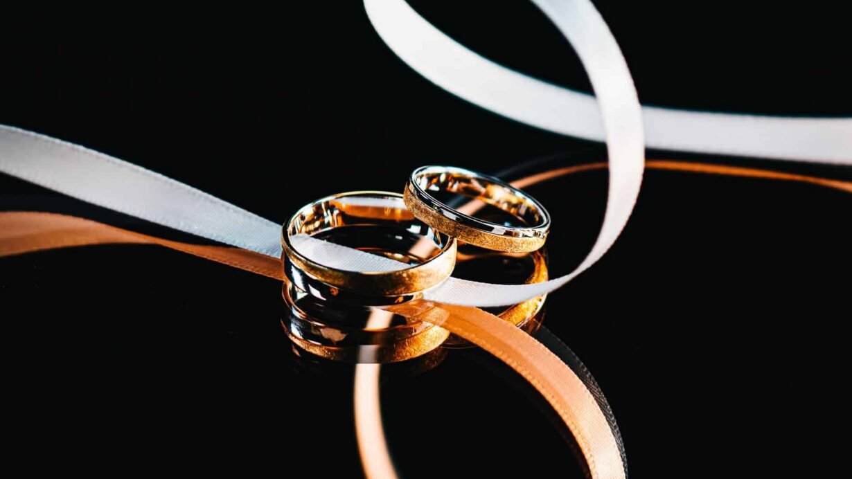 Deux alliances dorées avec rubans sur fond noir