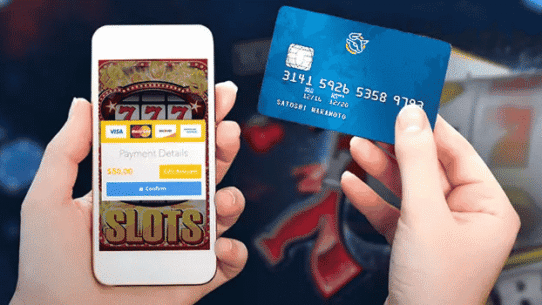 Main tenant un smartphone et une carte de crédit pour paiement de jeu