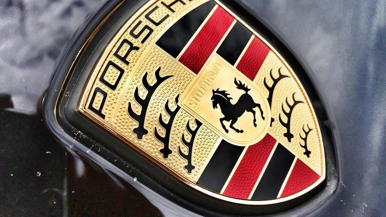 Gros plan du logo Porsche sur une carrosserie noire