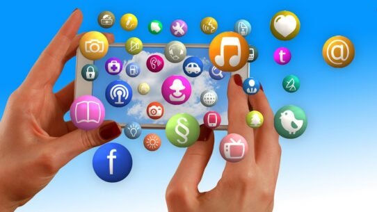 Mains tenant un smartphone entouré d'icônes d'applications