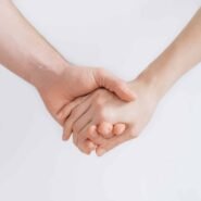 Deux mains entrelacées sur fond blanc