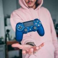 Manette de jeu bleue flottant au-dessus de la main d'une personne