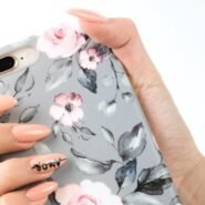 Main tenant une coque de téléphone à motifs floraux roses et gris