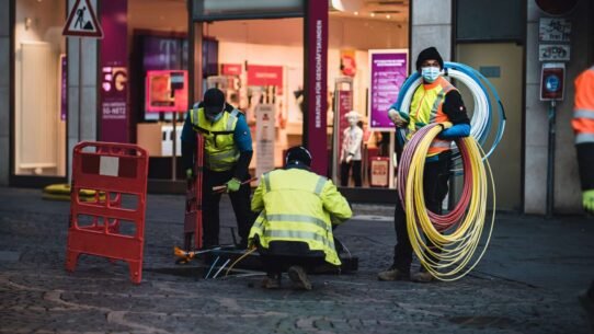 Techniciens installant des câbles à fibre optique devant un magasin