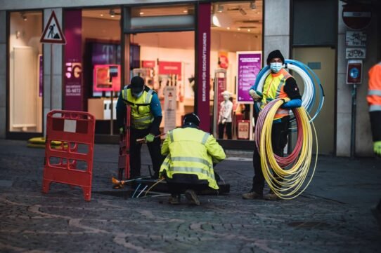 Techniciens installant des câbles à fibre optique devant un magasin