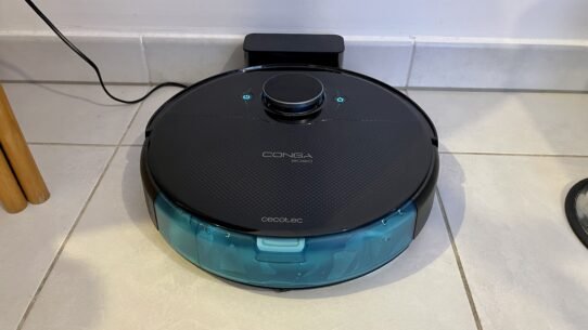 Robot aspirateur noir sur sa station de charge