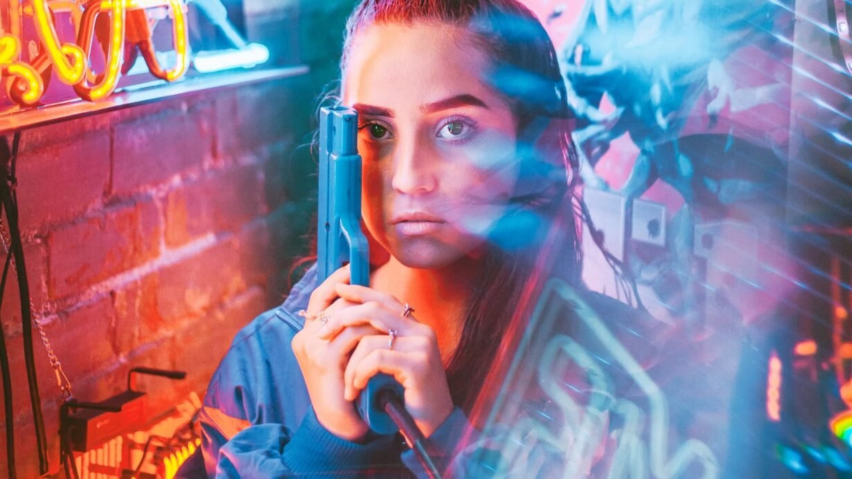 Femme avec un pistolet jouet dans des lumières néon colorées