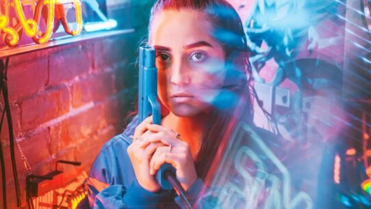 Femme avec un pistolet jouet dans des lumières néon colorées
