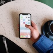 Personne utilisant un smartphone à côté d'une tasse de café