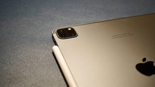 Tablette grise avec stylet posé sur une surface texturée