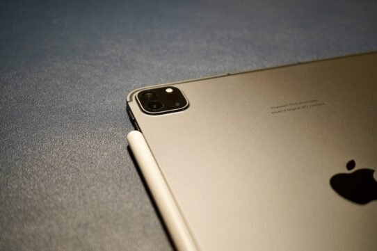 Tablette grise avec stylet posé sur une surface texturée