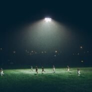 Joueurs de football sur un terrain éclairé la nuit par des projecteurs