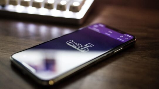 Smartphone affichant l'application Twitch sur une table en bois