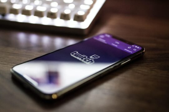 Smartphone affichant l'application Twitch sur une table en bois