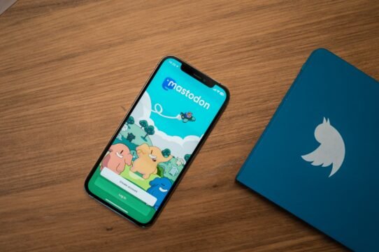 Téléphone affichant l'application Mastodon à côté d'un carnet Twitter