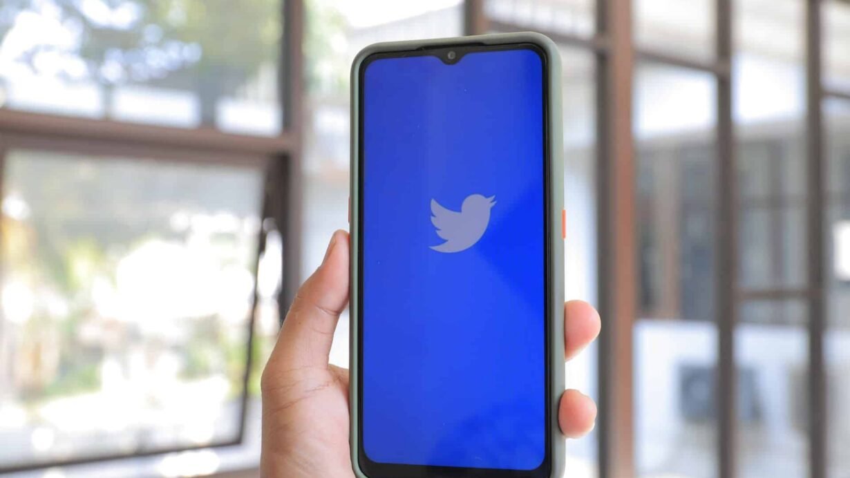 Main tenant un smartphone avec l'application Twitter ouverte