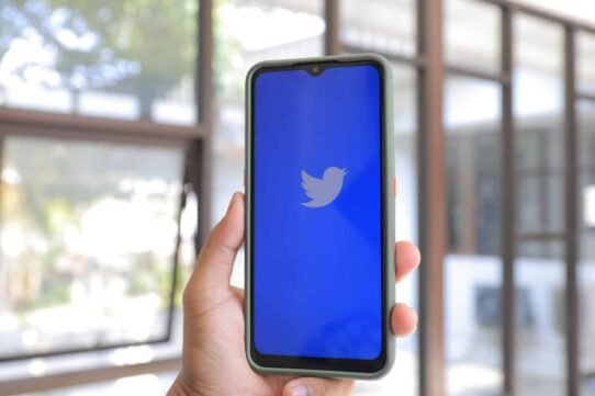Main tenant un smartphone avec l'application Twitter ouverte