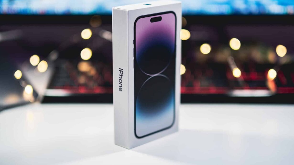 Boîte d'un nouvel iPhone devant un clavier éclairé