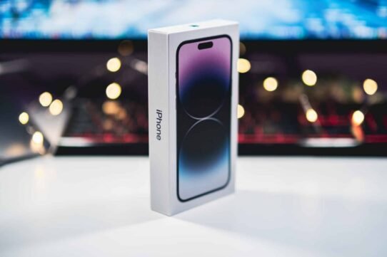 Boîte d'un nouvel iPhone devant un clavier éclairé