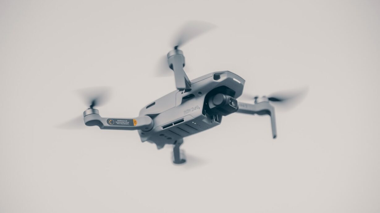 Drone gris en vol stationnaire sur fond clair