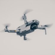 Drone gris en vol stationnaire sur fond clair