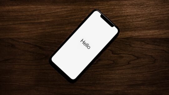Smartphone affichant Hello sur une table en bois