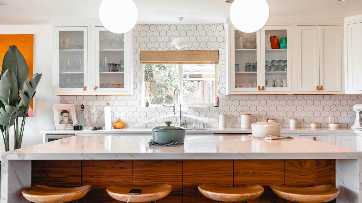 Cuisine moderne avec îlot central, tabourets en bois et décoration lumineuse